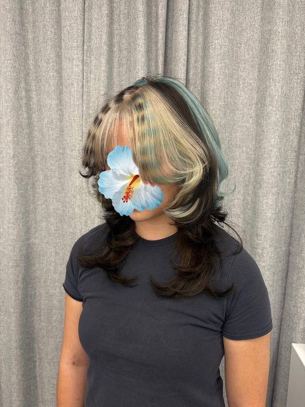 Blonde face framing with teal ribbons through the lengths