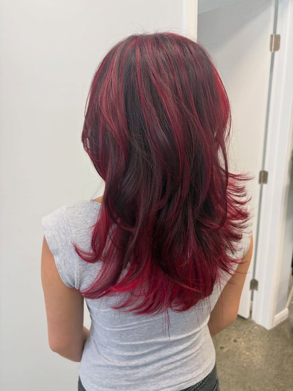 Dark roots melting into deep magenta through the lengths